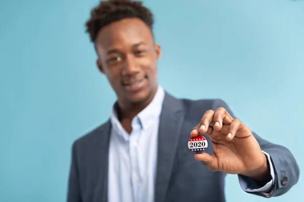 Счастливый африканский американский избиратель держит значок для голосования — стоковое фото