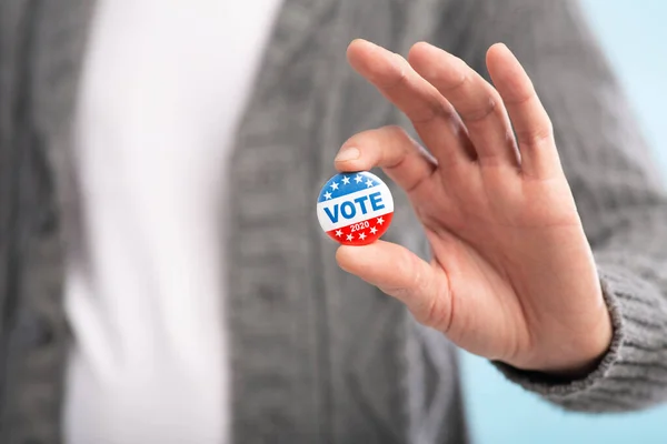 Cidadão americano cumpridor da lei segurando botão de voto na mão — Fotografia de Stock