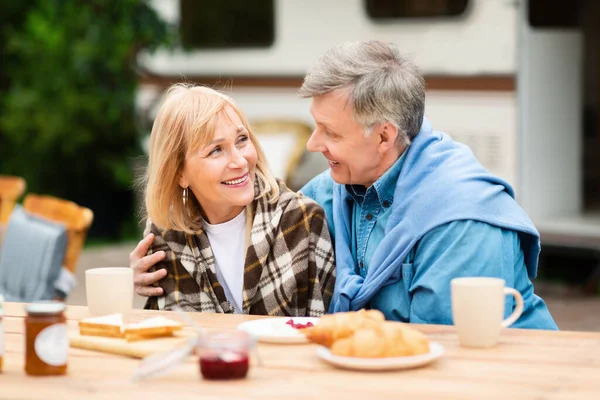 Reife Liebe. Liebender Ehemann und seine schöne Frau beim gemeinsamen Frühstück auf einem Campingausflug in der Nähe von Wohnwagen — Stockfoto