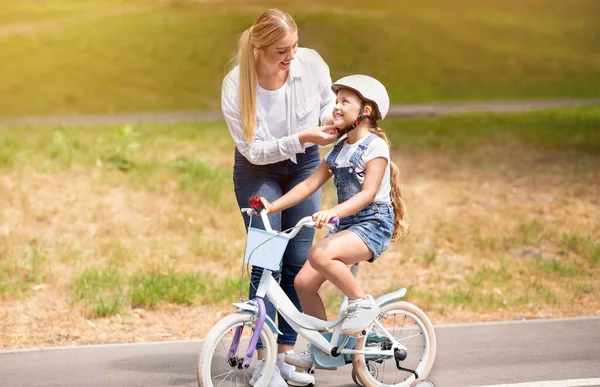 Madre insegnare figlia a cavalcare una bicicletta all'aperto nel parco — Foto Stock