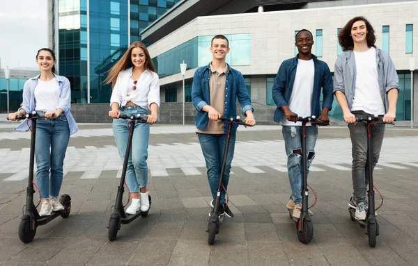 Šťastní přátelé mají pěknou jízdu na motorizované koloběžky — Stock fotografie