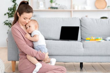 Anne-bebek duygusal bağı. Sevgi dolu anne, sevimli küçük oğluna sarılıyor.