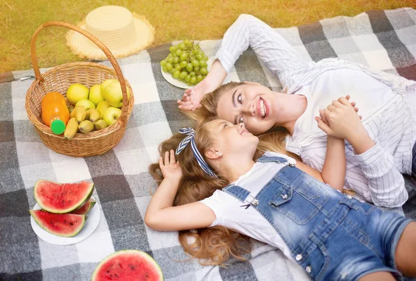 Mor och dotter har picknick liggande på filt i parken — Stockfoto