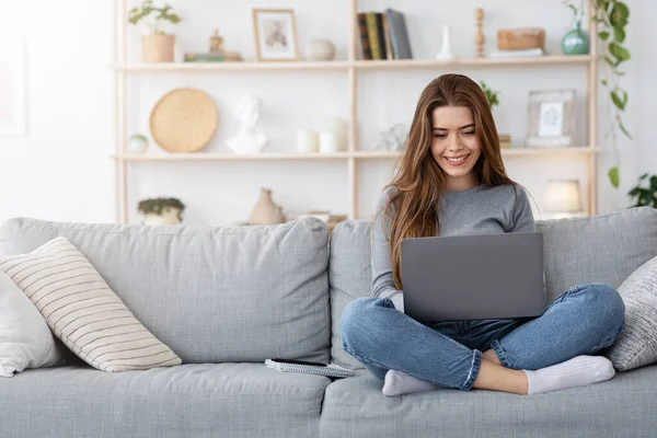 Mosolygó fiatal nő dolgozik otthonról, a laptop — Stock Fotó