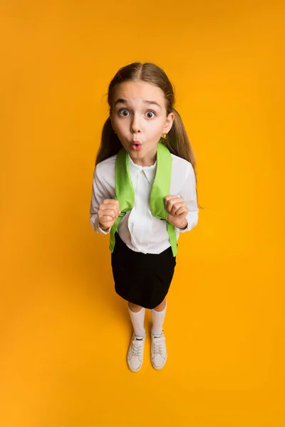 Funny Surprised Schoolgirl Looking At Camera Standing On Yellow Background — Stock Photo, Image