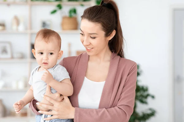 Porträt der jungen lächelnden Mutter mit ihrem entzückenden Kleinkind-Baby auf den Armen — Stockfoto