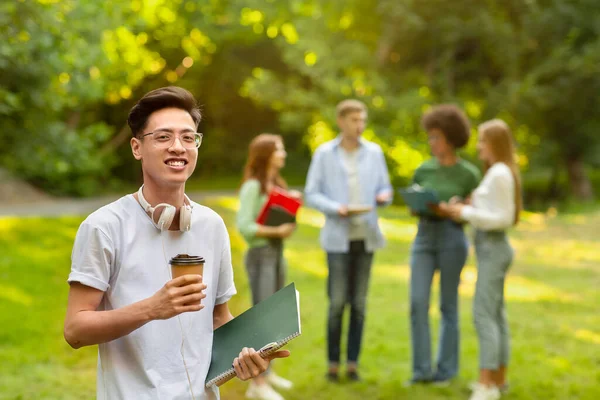 Campus Life. Asiático estudiante chico posando con bloc de notas y café en campus — Foto de Stock