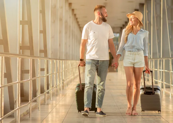 Felice coppia a piedi in aeroporto con i bagagli — Foto Stock