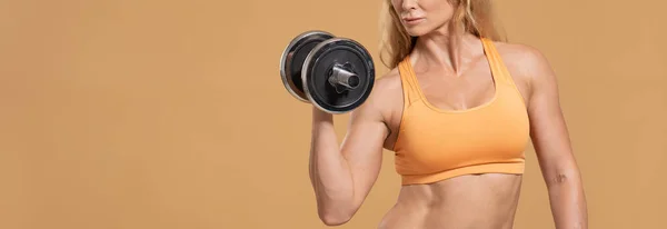 Preparándose para la competencia. Mujer de mediana edad en ropa deportiva haciendo ejercicio con pesas —  Fotos de Stock