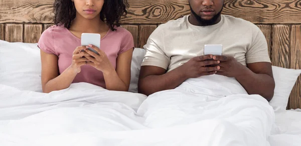 Recadré de l'homme et de la femme en utilisant des téléphones mobiles au lit — Photo