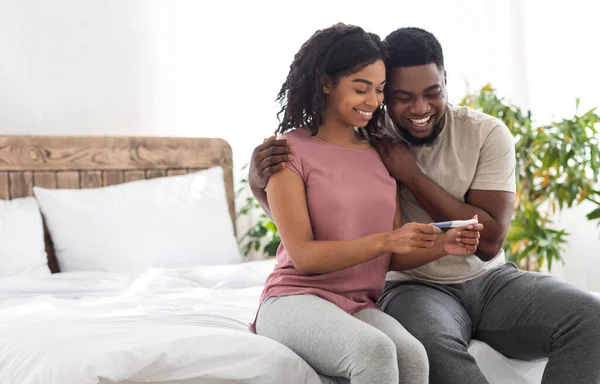 Feliz casal negro ter boas notícias, segurando teste de gravidez positivo — Fotografia de Stock