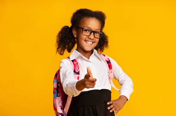 Gelukkig Afrikaans amerikaans schoolmeisje wijzend vinger bij camera in studio — Stockfoto