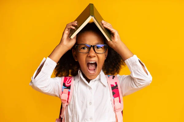 Freche afrikanische Schulmädchen Schreien Halten Buch Auf Kopf, Gelber Hintergrund — Stockfoto