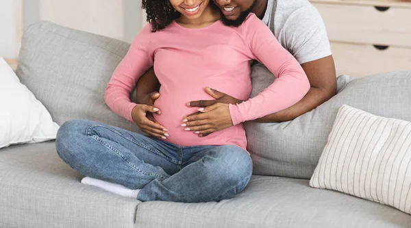 Gebeten van omhelzing van zwangere paar, woonkamer interieur — Stockfoto