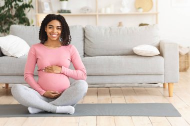 Siyahi bir kadının koca göbeğini kucaklamasını bekliyor.