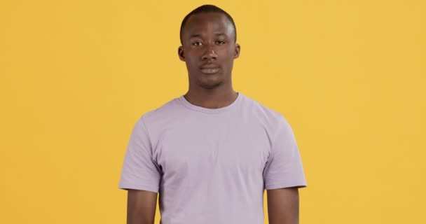 Młody czarny facet prosi o zachowanie tajemnicy, przyłożenie palca do ust — Wideo stockowe