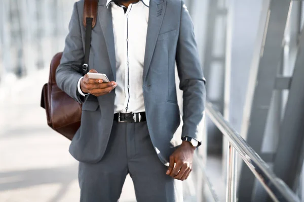 Hombre usando el teléfono celular caminando en el aeropuerto durante el viaje de negocios, recortado — Foto de Stock