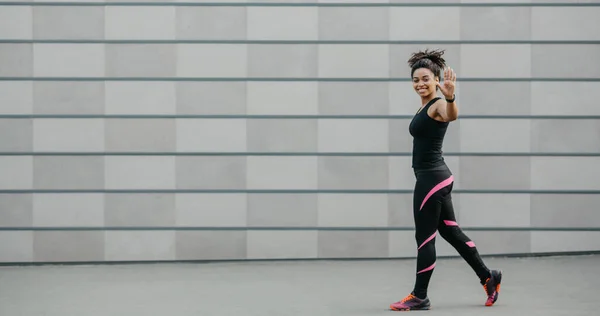 Blogueiro esportivo ou treinador para treino ao ar livre. Menina sorridente em sportswear com rastreador de fitness acenando mão para câmera — Fotografia de Stock