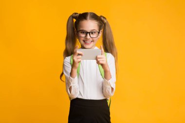 Stüdyo Çekimi sırasında Smartphone kullanarak Oyun Oynayan Heyecanlı Öğrenci Kız