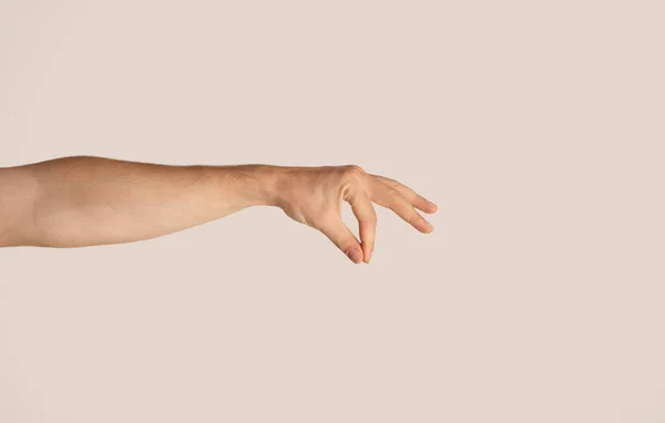 Primo piano di mano maschile che tiene qualcosa su sfondo chiaro, mockup per il design — Foto Stock