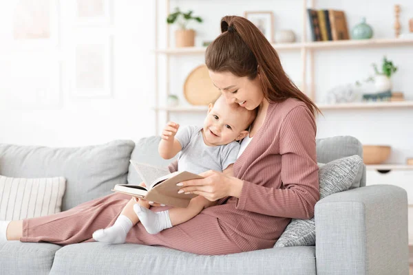 Anne, küçük tatlı oğluna evde kitap okuyor. — Stok fotoğraf