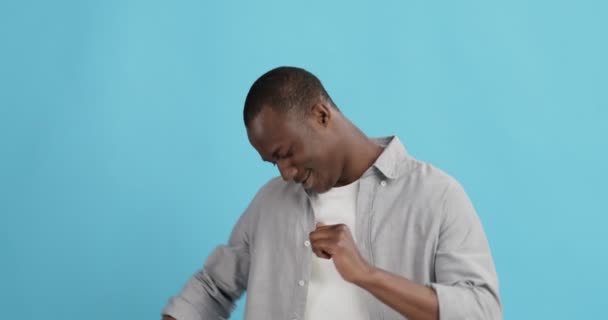 Позитивный африканский американец танцует, синий студийный фон — стоковое видео