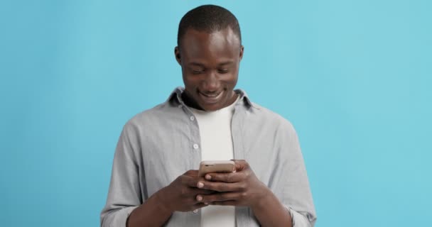 Χαρούμενος Αφροαμερικάνος που στέλνει μηνύματα στο κινητό. — Αρχείο Βίντεο