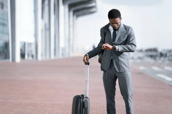 Empresario con maleta de viaje esperando un vuelo retrasado en el aeropuerto — Foto de Stock