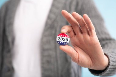 Mavi arkaplan üzerinde oy kullanma düğmesi tutan sahte isim