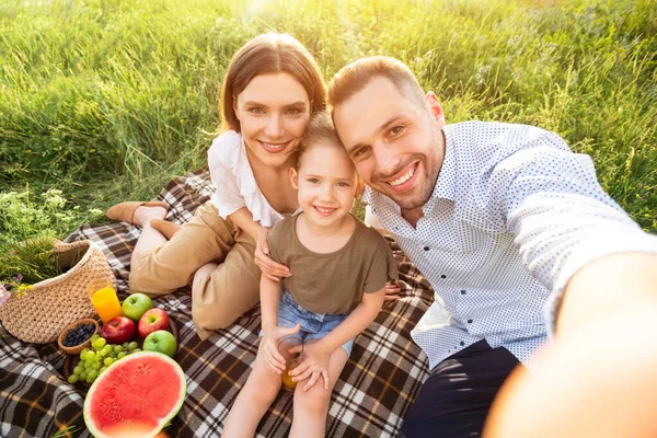 Mutlu aile kırsalda otururken selfie çekiyor. — Stok fotoğraf