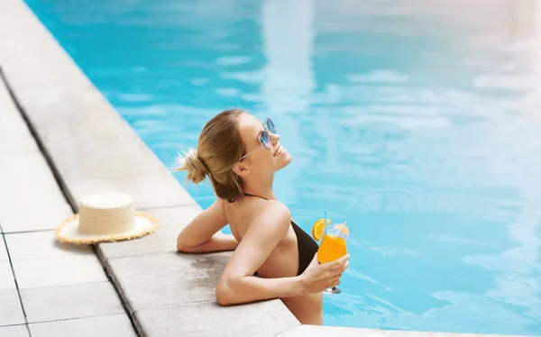 Mulher milenar encantadora com coquetel de verão relaxante na piscina, espaço vazio — Fotografia de Stock