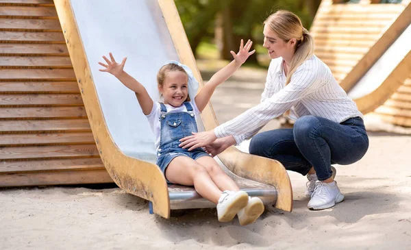 Flicka rida en bild ha kul med mor på lekplats — Stockfoto