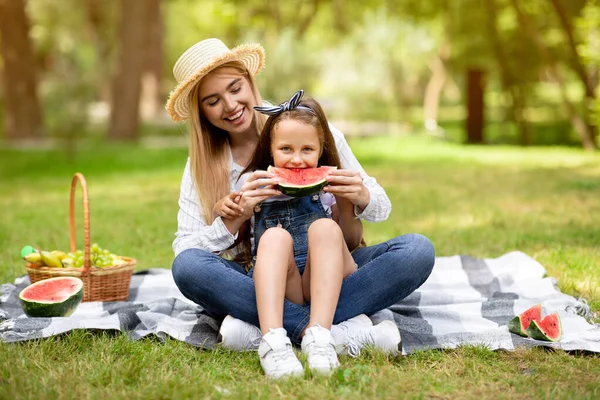 Glad mor matning dotter äta vattenmelon tillsammans på picknick utomhus — Stockfoto