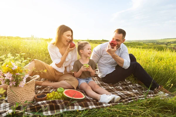 Молодая семья играет с фруктами на открытом воздухе — стоковое фото