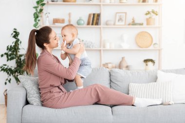 Anne-bebek duygusal bağı. Genç anne evde tapılası bebekle bağ kuruyor.