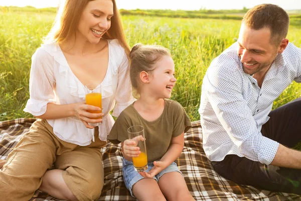 Família rindo bebendo suco de laranja de óculos — Fotografia de Stock