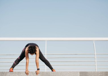 Karantina ve dışarıda çalışma. Spor giyimli Afrikalı Amerikalı kız. Akıllı saati var. Egzersiz yapıyor.