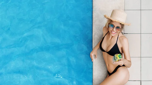 Visão aérea da sensual jovem em roupa de banho segurando refrescante coquetel de verão perto da piscina, espaço de cópia — Fotografia de Stock