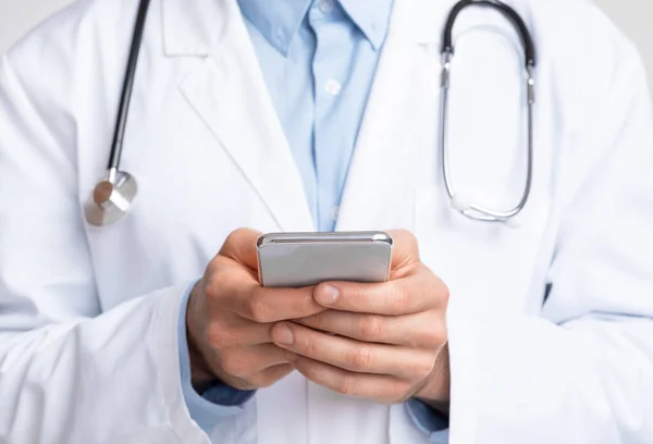 Primo piano del medico che tiene smartphone in mano — Foto Stock