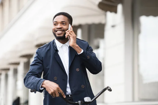 Beau homme d'affaires parlant sur le téléphone tenant vélo — Photo