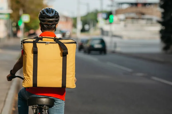 Şehir trafiği ve bisiklet teslimat servisi. Miğferli kurye, çantalı, bisikletli. — Stok fotoğraf