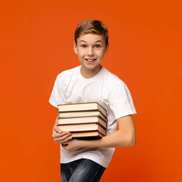 Nastolatek uśmiechający się z kupą książek w rękach — Zdjęcie stockowe