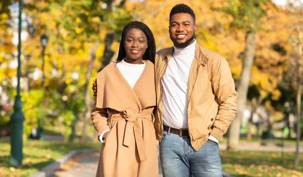 Alegre afro casal posando no outono parque, gostando de passar tempo ao ar livre — Fotografia de Stock