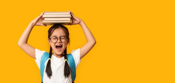 Συναισθηματική ασιατική μαθήτρια Screaming Posing με βιβλία πάνω από κίτρινο φόντο — Φωτογραφία Αρχείου
