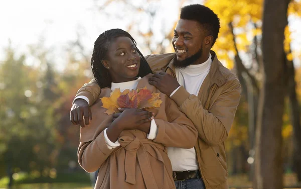 Romantik Afrikalı çift, sonbahar parkında birbirlerine sarılıyorlar. — Stok fotoğraf