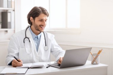 Genç doktor internette iş arkadaşlarıyla sohbet ediyor.