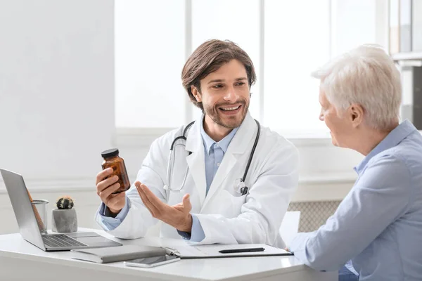 Young professional doctor prescripting new pills to senior woman — Stock Photo, Image