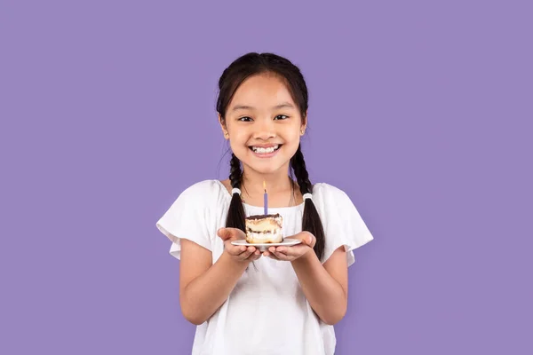 Felice asiatico ragazza holding b-day torta making desiderio, viola sfondo — Foto Stock