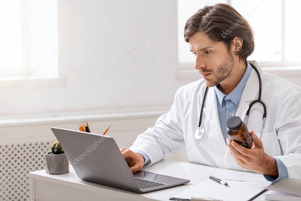 Young doctor reading instruction for pills on laptop