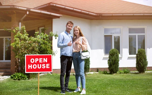 Proprietários de casa feliz com chave de casa na frente de sua nova propriedade, espaço vazio — Fotografia de Stock